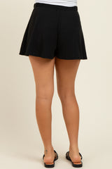 woman wearing black maternity shorts with a relaxed fit, showing the back view and a casual style