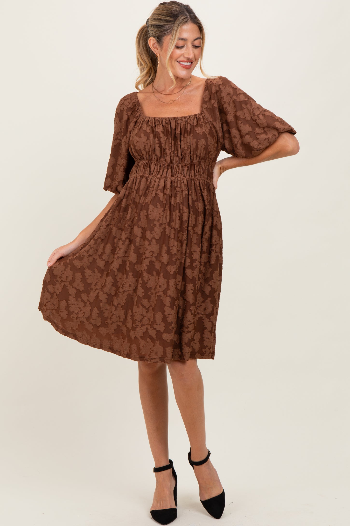 woman wearing a brown floral maternity dress with a square neckline and short puff sleeves