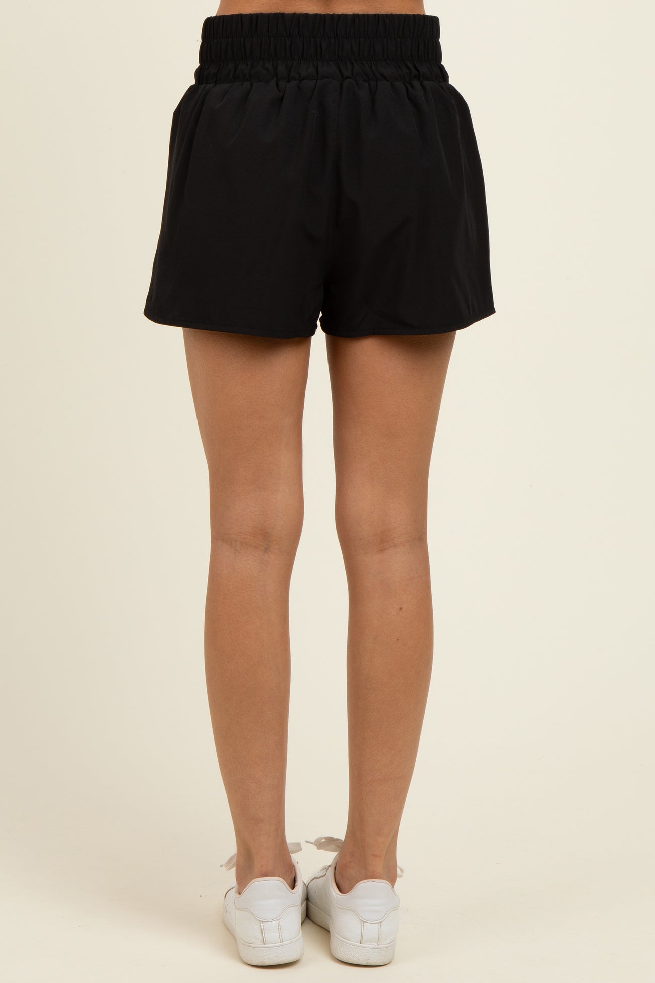 woman wearing black elastic waistband shorts, shown from the back