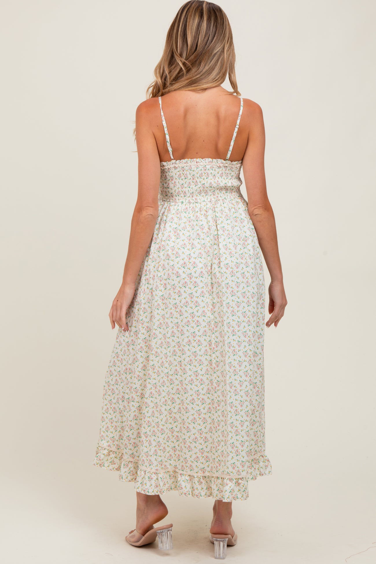 woman wearing a floral maxi maternity dress with adjustable spaghetti straps and a smocked back design