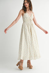 woman wearing a floral print maxi dress with thin straps and a smocked bodice, paired with platform sandals