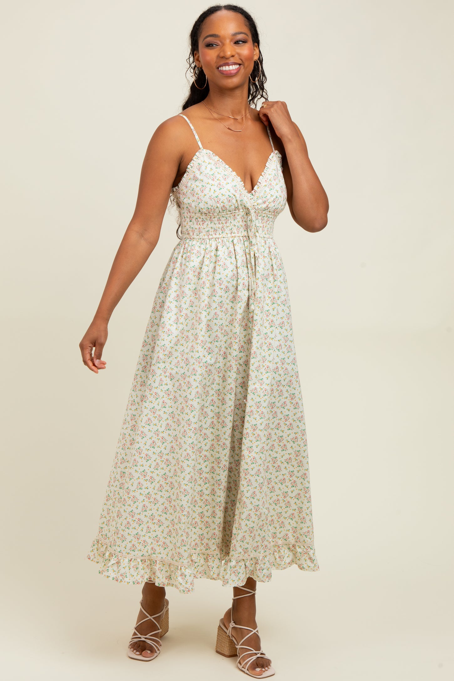 woman wearing a pastel floral maxi dress with adjustable straps and a fitted bodice