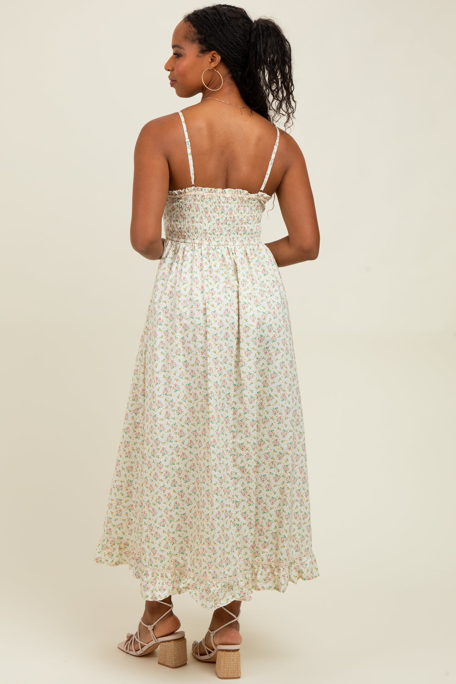 woman wearing a white floral midi dress with smocked bodice and adjustable straps, shown from the back