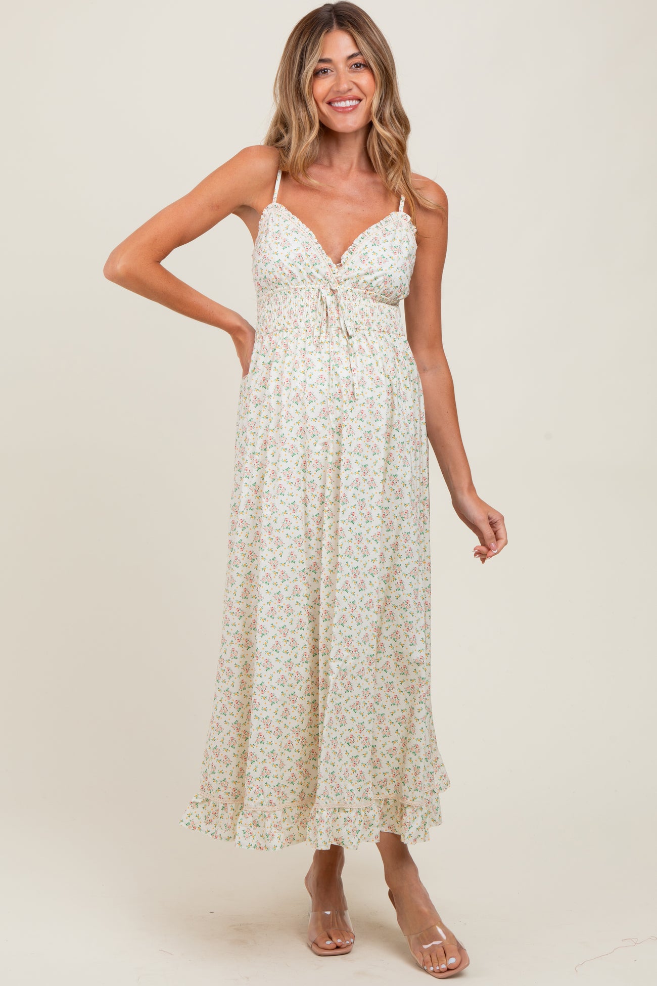 woman wearing a floral print maternity maxi dress with adjustable straps and a tie-front detail