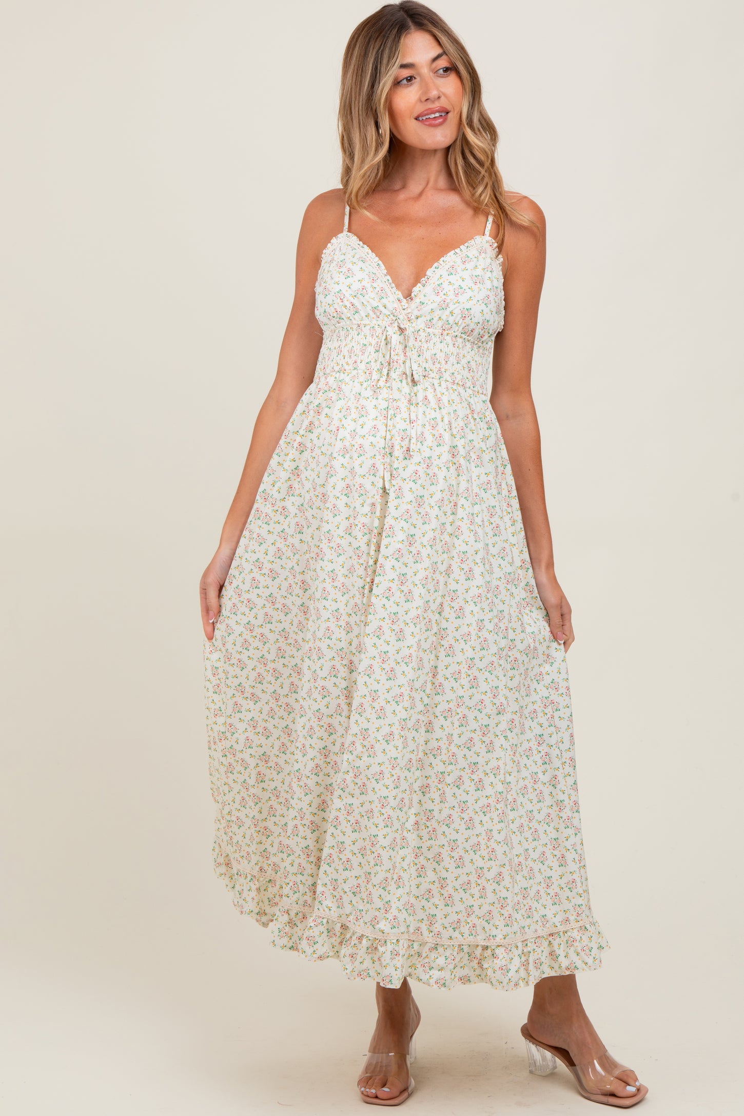 woman wearing a floral maxi maternity dress with adjustable straps and a tie front detail