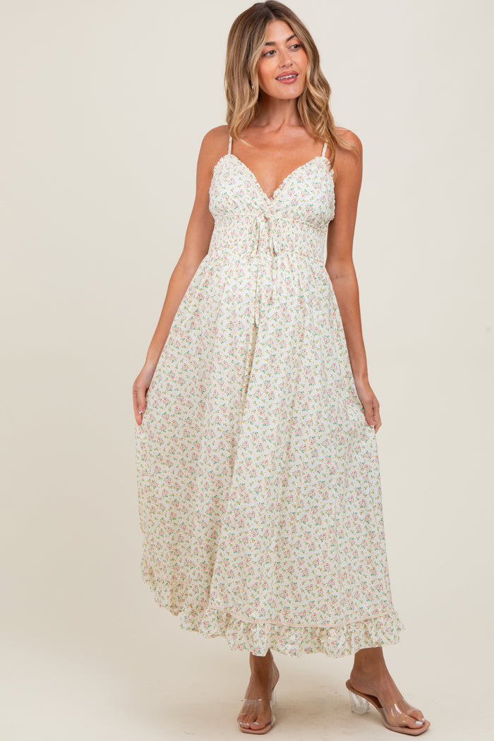 woman wearing a floral maxi maternity dress with adjustable straps and a tie front detail