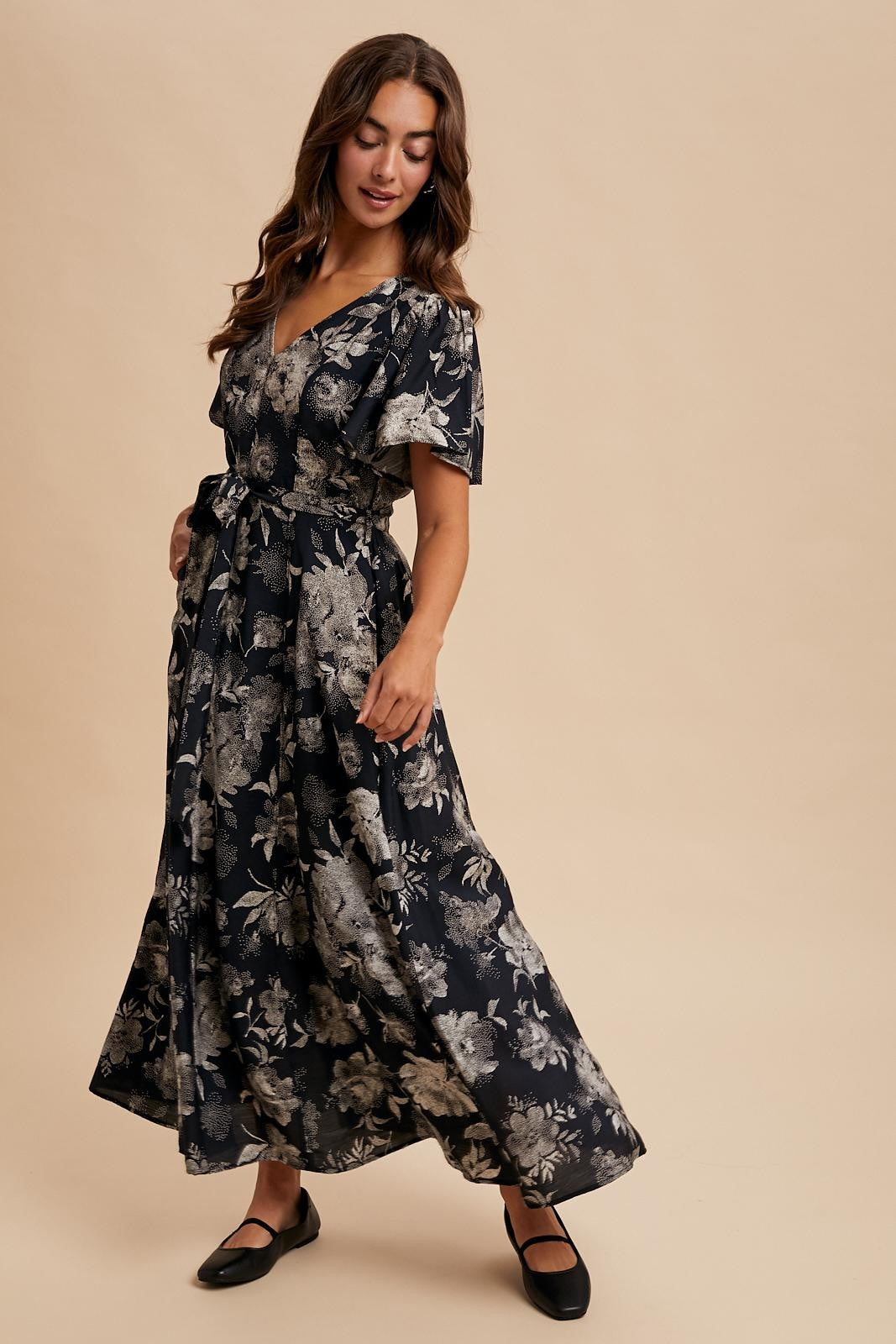 woman wearing a navy blue floral maxi dress with a v-neckline and short sleeves