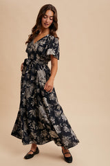 woman wearing a navy blue floral maxi dress with a v-neckline and short sleeves