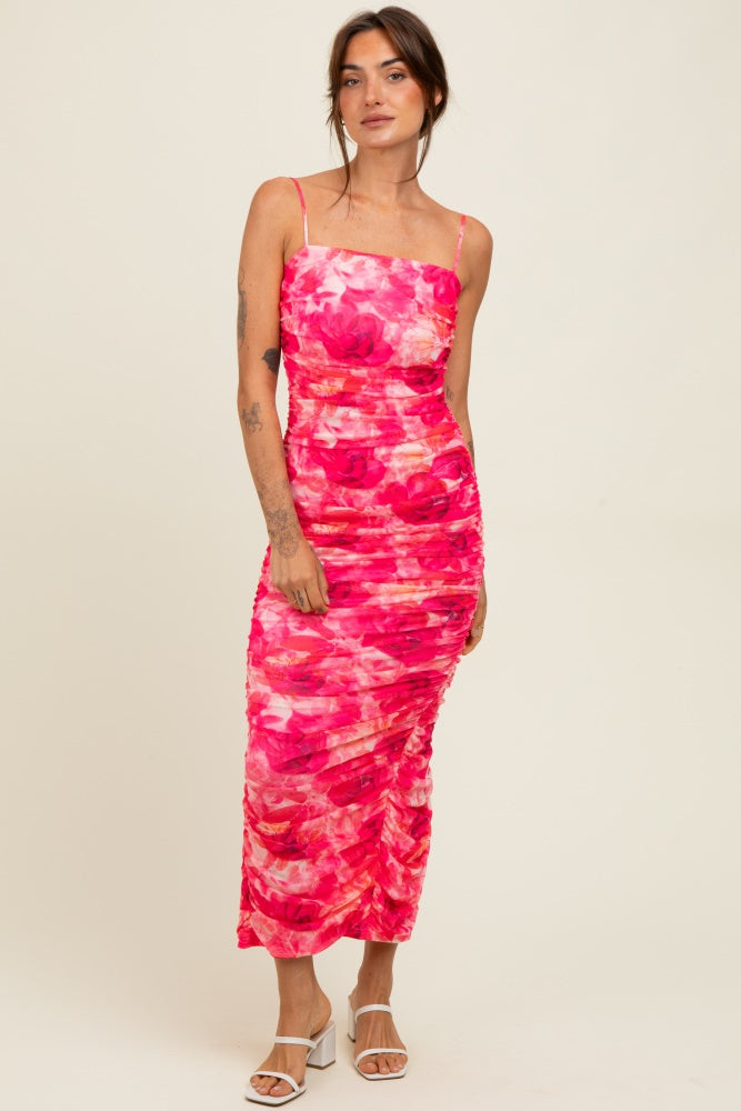 woman wearing a pink floral midi dress with ruching and spaghetti straps