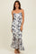 woman wearing a fitted white and gray tie-dye maxi dress with a mermaid hem and spaghetti straps