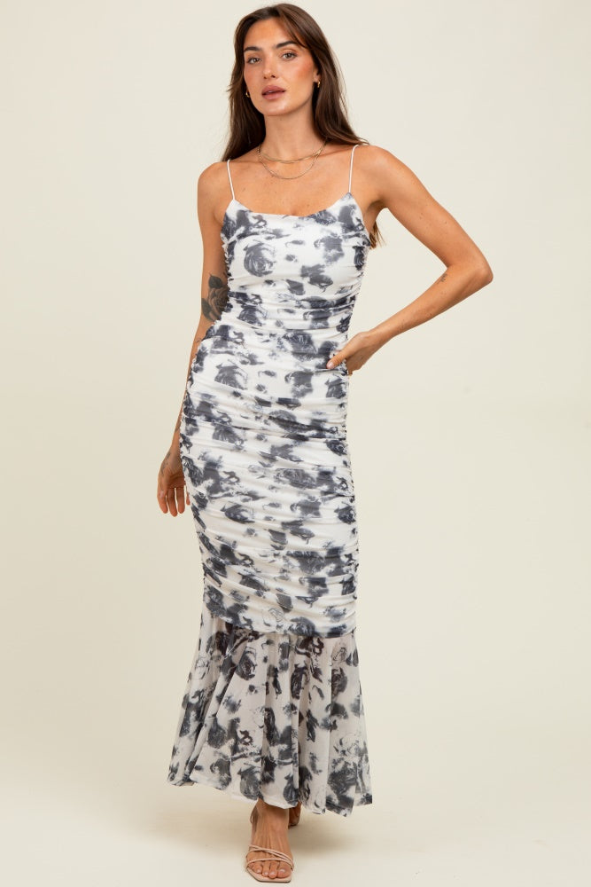 woman wearing a white and gray floral print maxi dress with a fitted bodice and flared hemline