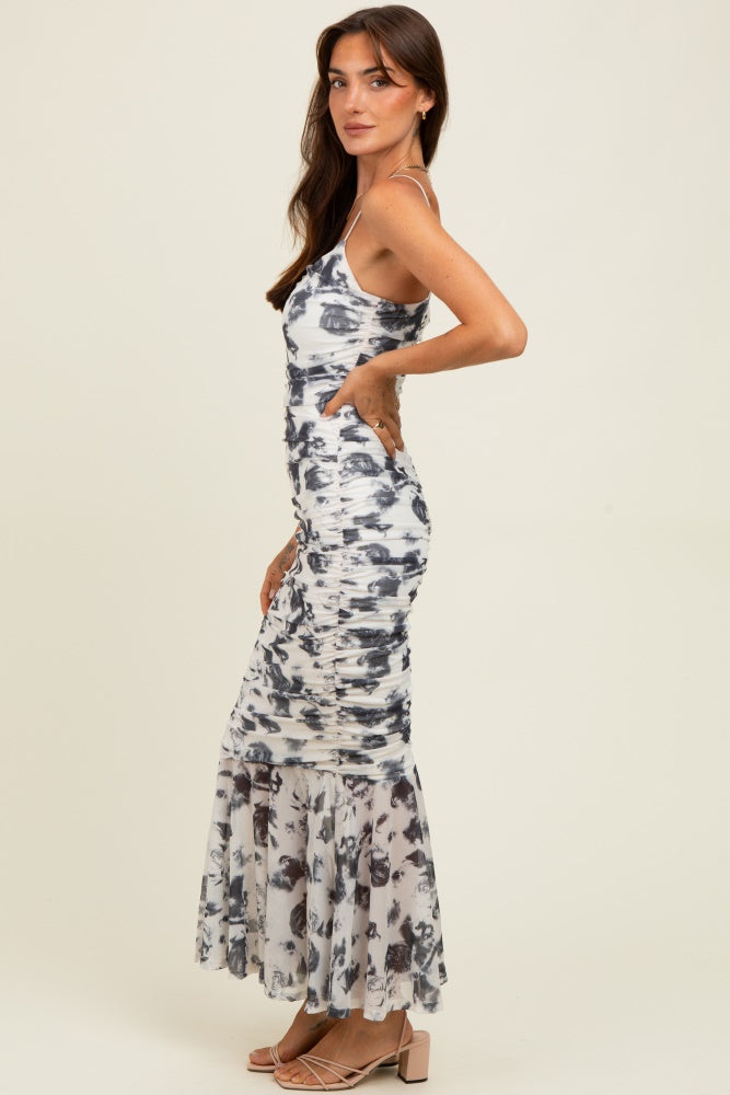 woman wearing a white and gray tie-dye maxi dress with ruching and a flared hem