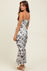 woman wearing a black and white tie-dye ruched maxi dress with a flared hem and adjustable straps