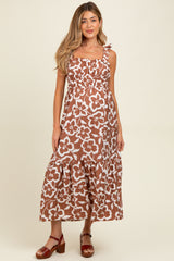 woman wearing a brown floral maternity maxi dress with ruffled straps and a tiered skirt