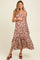 woman wearing a brown floral print maternity maxi dress and holding her baby bump