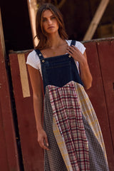 woman wearing a denim and plaid mix overall dress over a white t-shirt