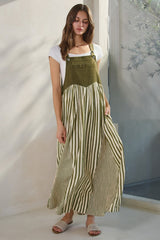 woman wearing a green and white striped maxi dress with a fitted bodice and gathered skirt