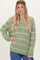 woman wearing a green and pink striped oversized sweater with a v-neck and long sleeves