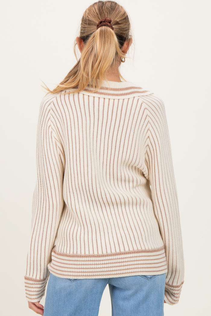 woman wearing a cream and brown striped maternity sweater, showing the back view