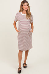 woman wearing a striped maternity dress with short puff sleeves and pockets, showcasing her baby bump