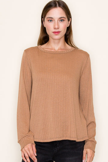 woman wearing a ribbed long sleeve shirt in a warm brown color with a round neckline