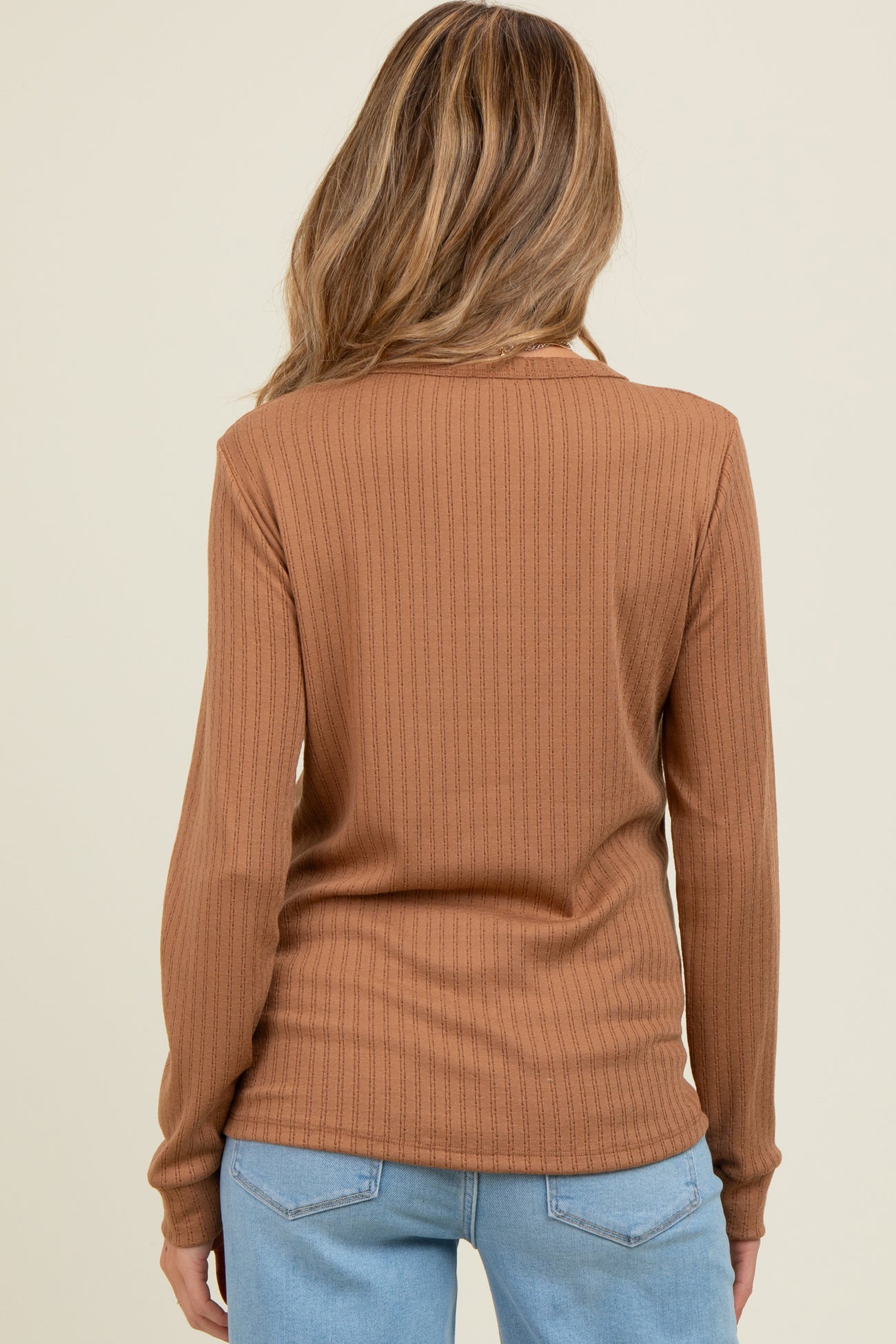 woman wearing a brown ribbed long sleeve maternity top, seen from the back