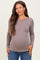 woman wearing a mauve long sleeve maternity top with a fitted style and visible baby bump