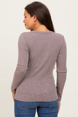 woman wearing a mauve long sleeve maternity top, showing the back view, paired with blue jeans