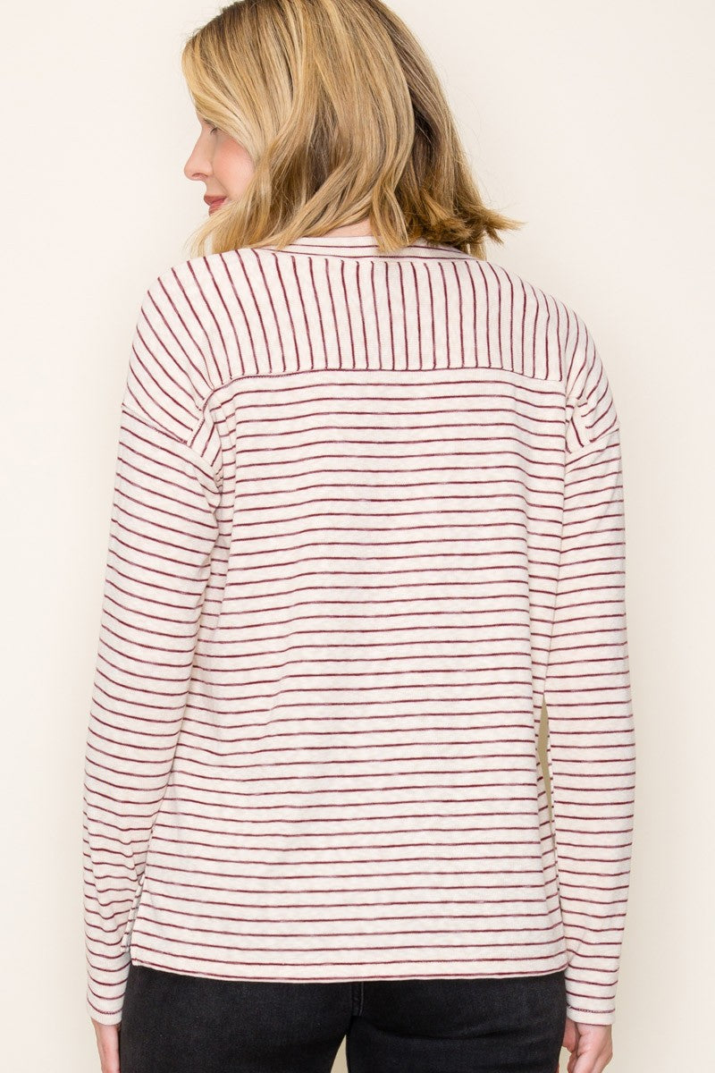 woman wearing a cream and burgundy striped long sleeve top, view from the back