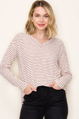 woman wearing a cream and maroon striped long sleeve v-neck top and black jeans