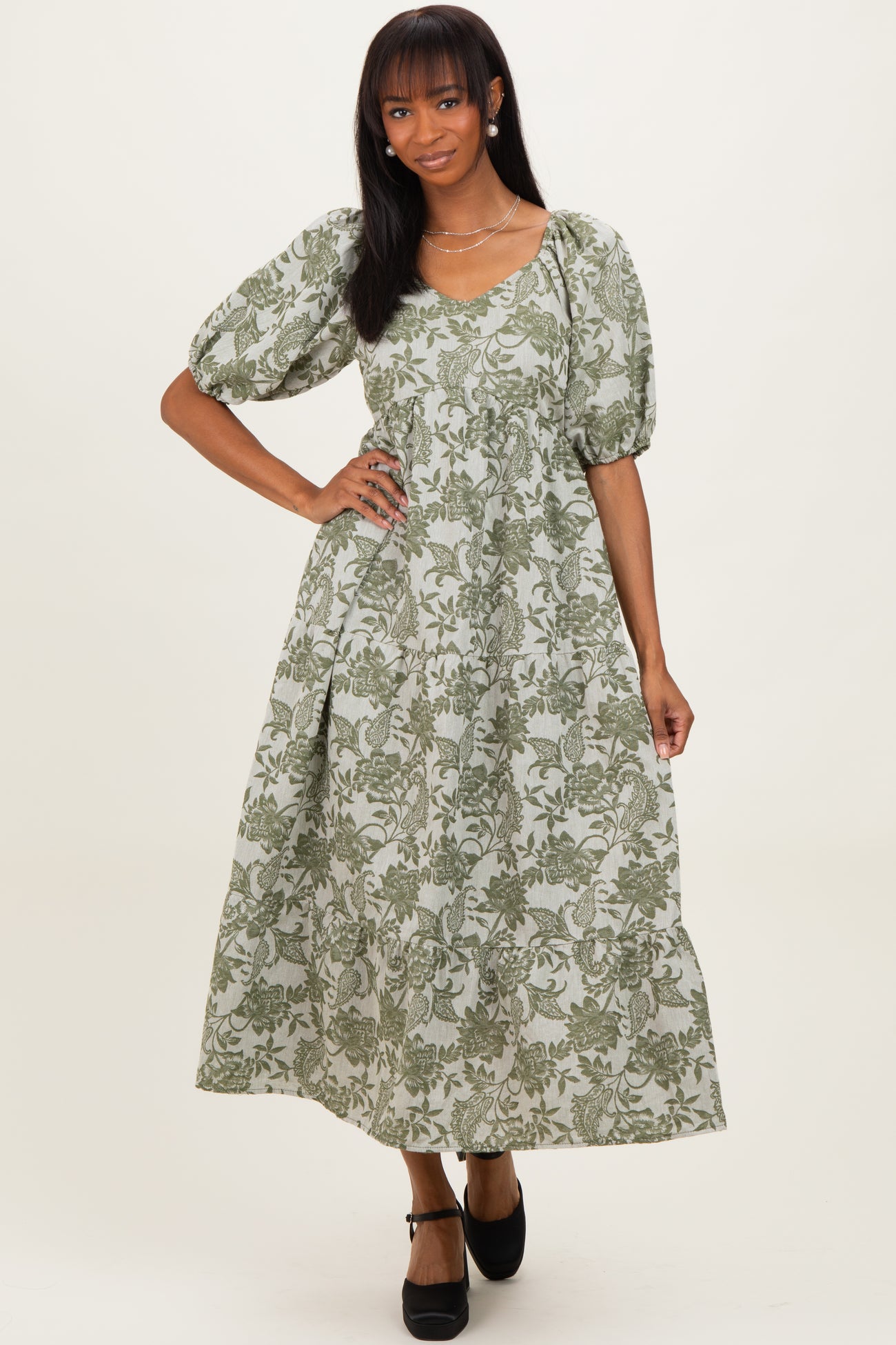 woman wearing a green floral maxi dress with puff sleeves and a scoop neckline