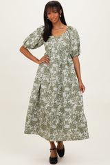 woman wearing a green floral maxi dress with puff sleeves and a scoop neckline