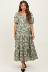 woman wearing a green floral print maternity maxi dress with puff sleeves and a v-neckline
