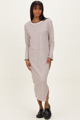 woman wearing a long striped midi dress with long sleeves and side slits, paired with black loafers