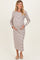 woman wearing a striped maternity dress, holding her baby bump, with long sleeves and a midi length