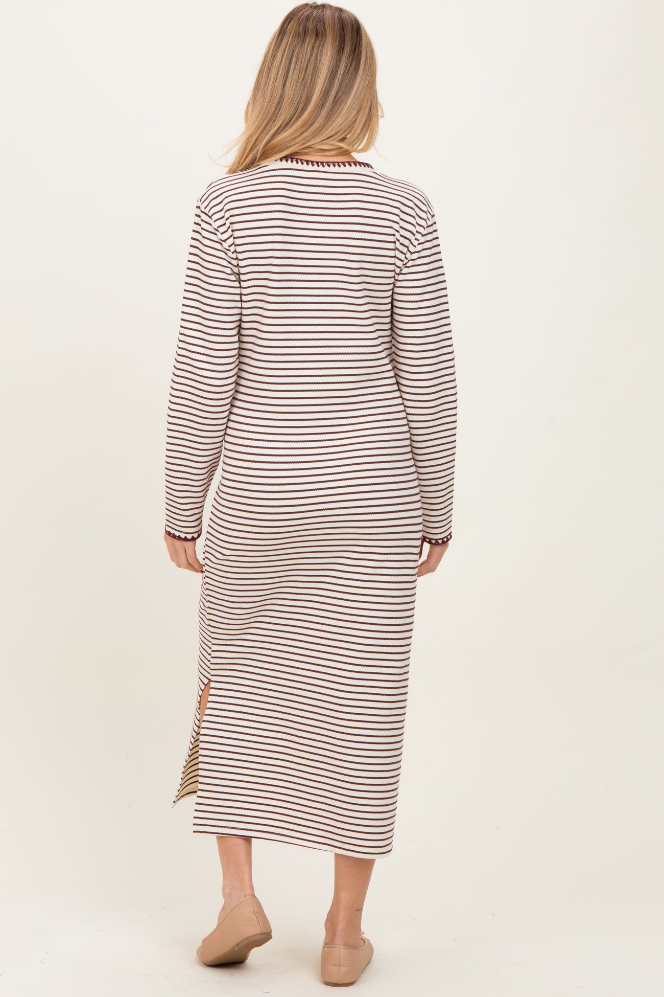 woman wearing a striped long sleeve maternity dress with side slits, showing the back view