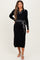 woman wearing a black ribbed maternity dress with a white collar and tie waist detail, showing her baby bump