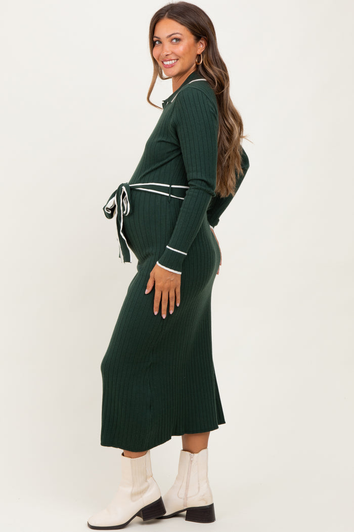 woman wearing a dark green ribbed maternity dress with a tie waist, showcasing her baby bump