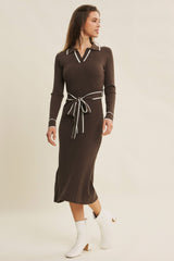 woman wearing a brown ribbed midi dress with a white collar and tie waist, paired with white ankle boots