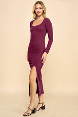 woman wearing a burgundy ribbed long sleeve dress with a side slit and a scoop neckline