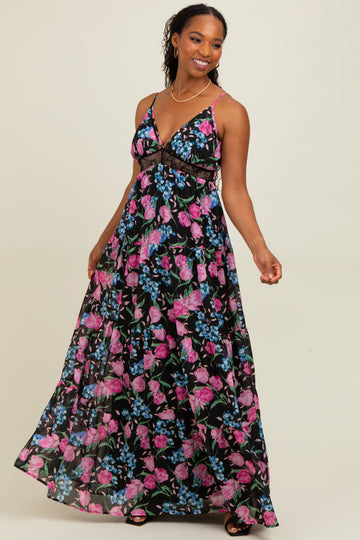 woman wearing a black maxi dress with pink and blue floral print and thin straps