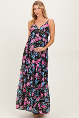 woman wearing a black floral maternity maxi dress and holding her baby bump