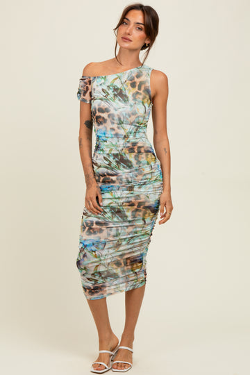 woman wearing a one-shoulder bodycon dress with a colorful leopard and floral print