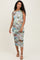 woman wearing a multi-colored floral print maternity dress with a one-shoulder design and a fitted silhouette, showing a baby bump