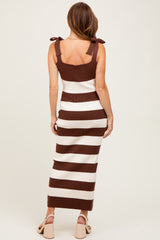 woman wearing a brown and white striped ribbed maxi dress with tie details on the shoulders, viewed from the back
