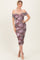 woman wearing a purple and pink off-shoulder floral bodycon dress with ruched detailing and a midi length