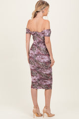 woman wearing a lavender floral off-the-shoulder midi dress with a fitted silhouette and ruched detailing