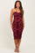 woman wearing a maroon strapless maternity dress with ruching and a fitted silhouette, showcasing a baby bump