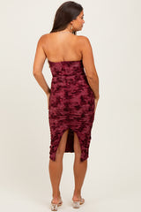 woman wearing a burgundy strapless maternity dress with ruching and a high slit in the back