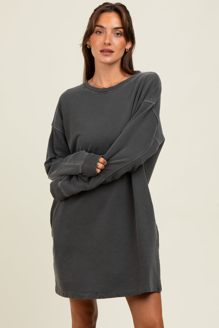 woman wearing a charcoal gray oversized sweatshirt dress with long sleeves and a relaxed fit